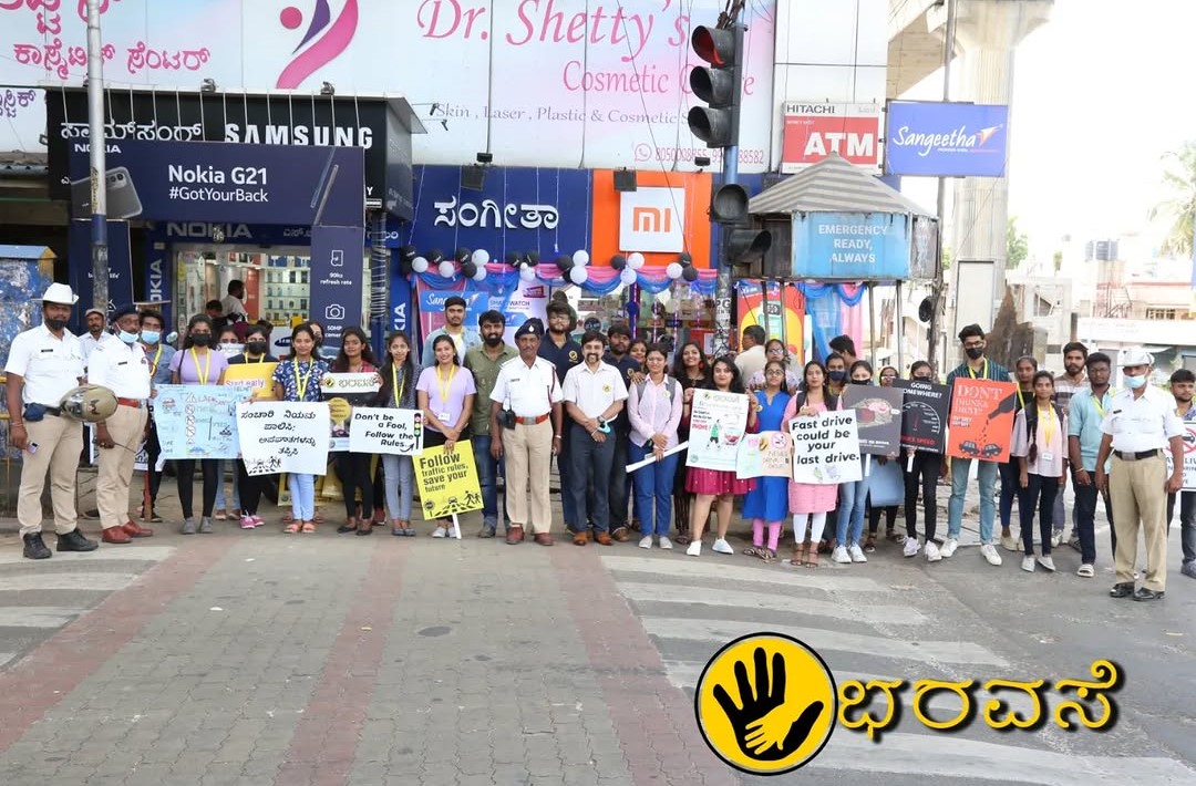Awareness campaign volunteers holding a road safety placard